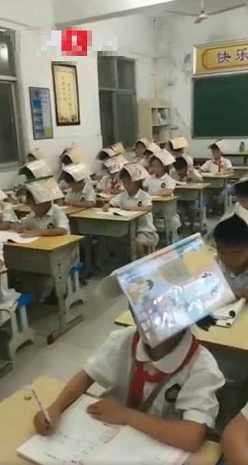 小學(xué)生頭頂課本寫字，網(wǎng)友：還是老師厲害，專治駝背